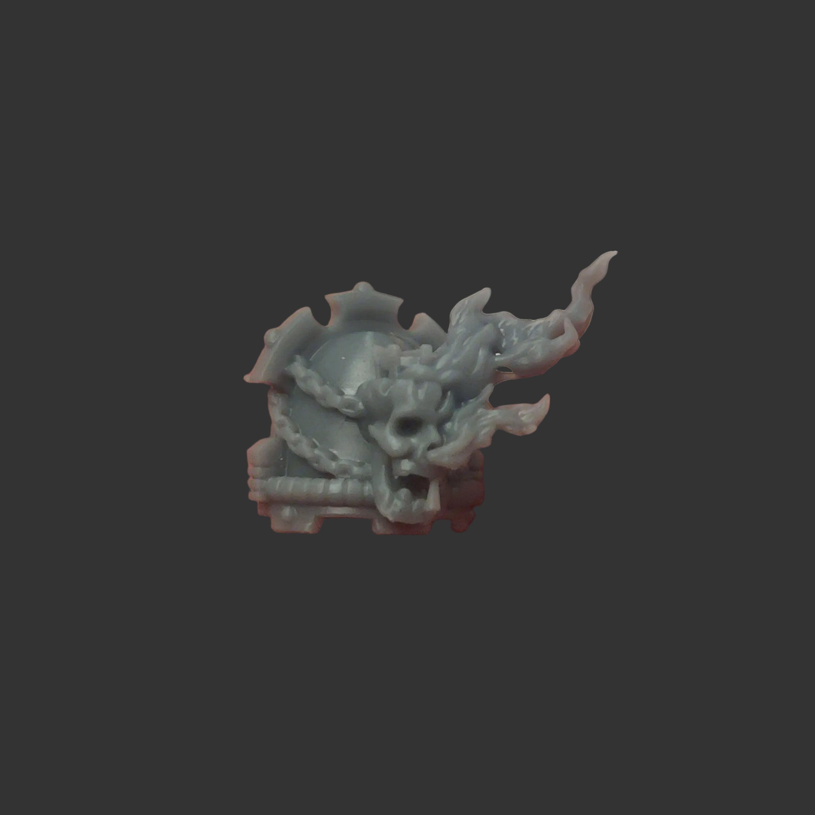 Small shoulder pad with flaming skull and chains.