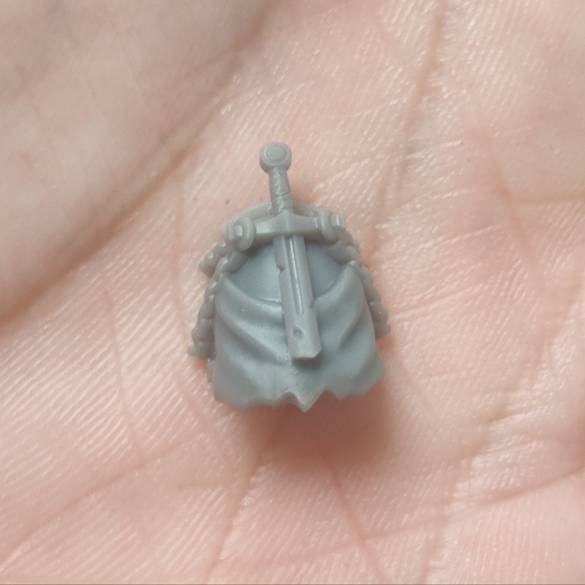 Small gray figurine held in a hand