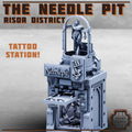 Tattoo station model with 'The Needle Pit' branding on a gray background
